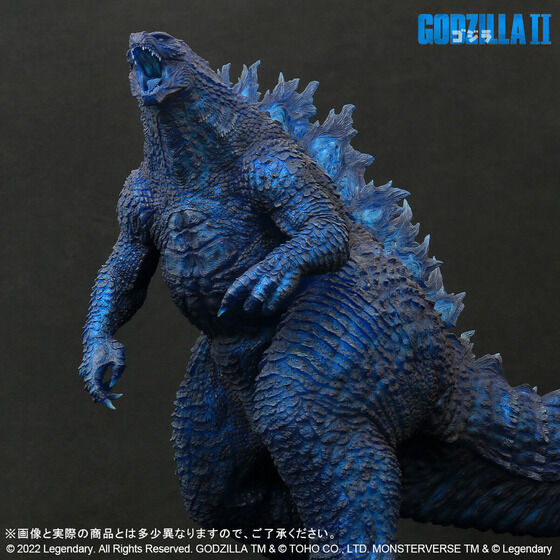 Một hình ảnh quảng cáo cho "Dòng Gigantic Godzilla (2019) Blue Clear Ver." hình từ Premium Bandai với hình ảnh ba phần tư mặt trước của món đồ chơi từ phía trước.
